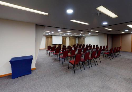 a conference room with red chairs and a podium at Estanplaza Nações Unidas in Sao Paulo