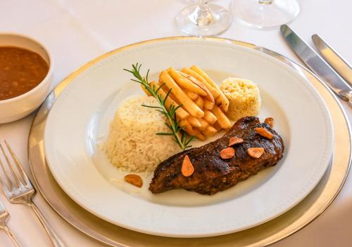 a plate of food with rice and meat and carrots at Estanplaza Nações Unidas in Sao Paulo