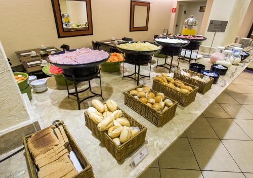 a buffet with many baskets of food on a table at Estanplaza Nações Unidas in Sao Paulo
