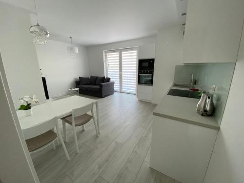 een keuken en een woonkamer met een tafel en een bank bij Flat4You II in Poznań