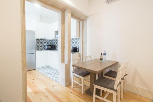 a kitchen and dining room with a wooden table and chairs at Janelas de São Bento 3 by Porto City Hosts in Porto