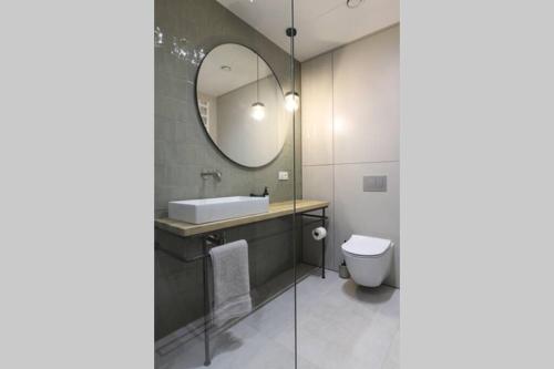 a bathroom with a sink and a mirror at Nowoczesny apartament w Puszczy Białowieskiej in Hajnówka