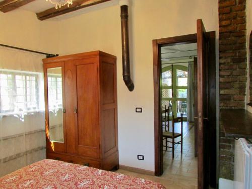 a bedroom with a wooden cabinet and a mirror at Agriturismo "Borgo Madonna degli Angeli" - charming cottages in the gardens ! in Tocco da Casauria