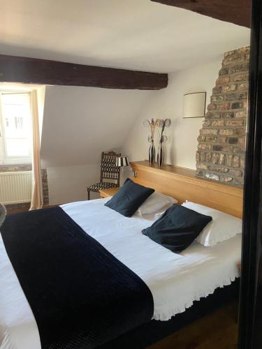 a bedroom with two beds with black and white pillows at Chambres D'Hotes Rekko in Maastricht