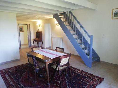 a dining room with a table and a blue staircase at Château MontPlaisir charming b&b in Provence in Valréas