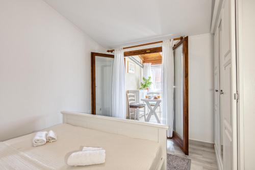 a white bedroom with a bed and a mirror at Penthouse Zola with private parking in Medulin