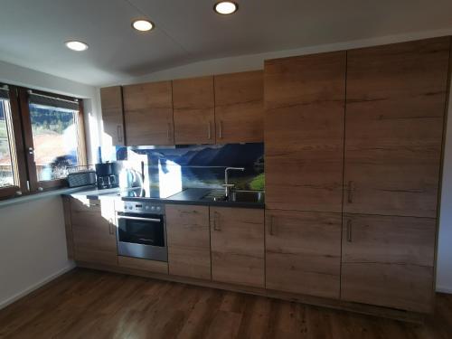 a kitchen with wooden cabinets and a sink at Ferienwohnung Stillleben in Ofterschwang