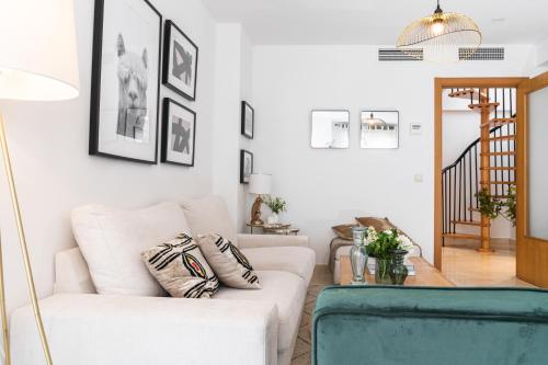 a living room with a white couch and a green ottoman at Pacificio Beachfront in Málaga