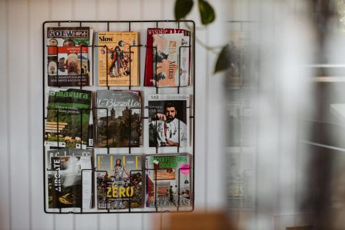 a collage of magazines on a shelf in a window at Salon Win Wine Bar & Apartments in Jasło
