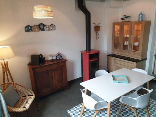 - une cuisine avec une table blanche et une cuisinière dans l'établissement Au coeur de Veules-les-Roses/Le P'ti Veules, à Veules-les-Roses