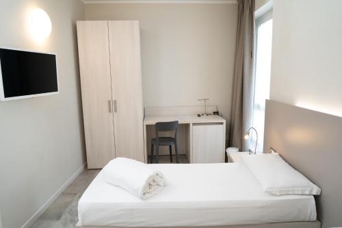 a hotel room with two beds and a desk at Hotel Europa in Dossobuono