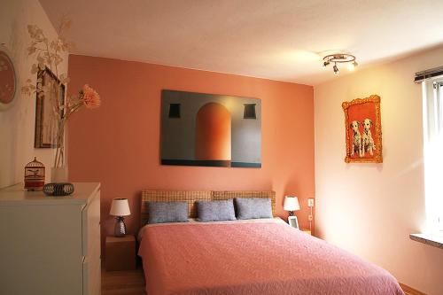 a bedroom with a bed with orange walls at HAUS MIT KUNST ZWISCHEN WALD UND SEE in Leipzig