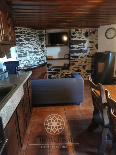 a living room with a blue couch in a kitchen at CHR Talasnal_Casa da Pedra in Lousã