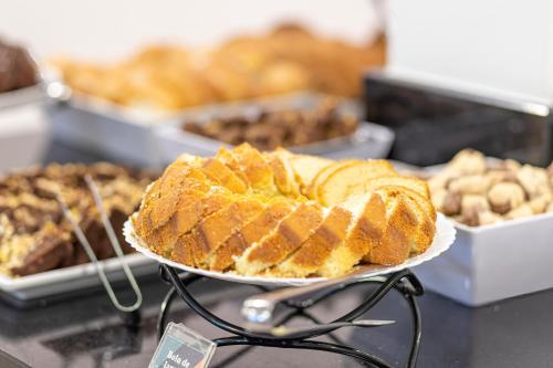 a cake on a plate on a counter with other pastries at Hotel Sagres Praia in Balneário Camboriú