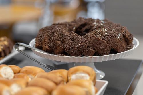 a chocolate cake on a plate with donuts on a table at Hotel Sagres Praia in Balneário Camboriú