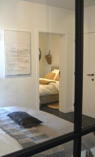 a bedroom with a mirror and a bed in a room at Sfeervol appartement te Blankenberge in Blankenberge
