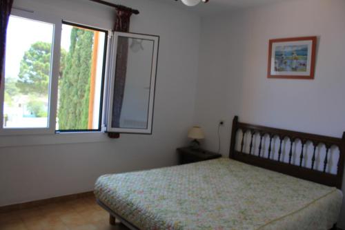 una camera da letto con un letto con specchio e una finestra di Riells Blau a L'Escala