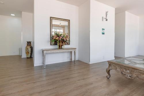 a white room with a table and a mirror at Hotel Sagres Praia in Balneário Camboriú