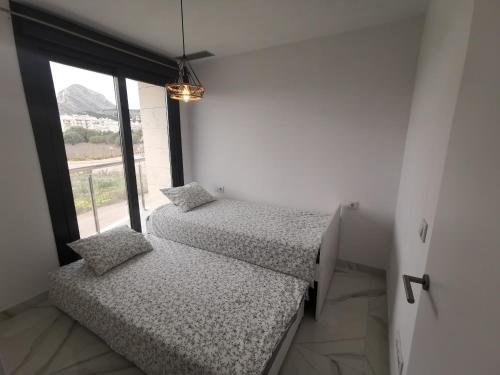 two beds in a room with a window at Luxury apartment Maracuya Javea Port in Jávea