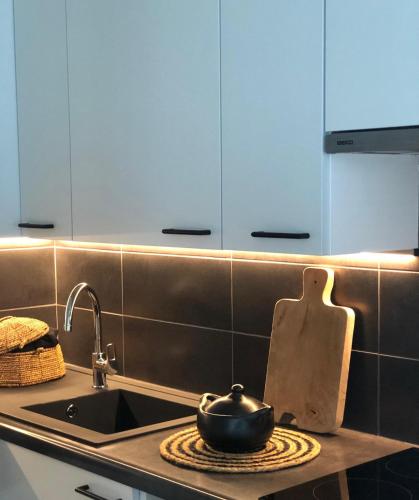 a kitchen with a sink and a pot on a stove at Sfeervol appartement te Blankenberge in Blankenberge