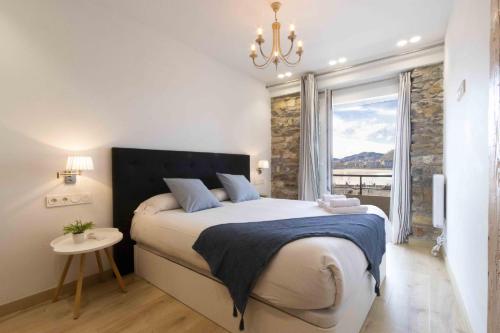 Un dormitorio con una cama grande y una ventana en The Rentals Collection - Monpas, en San Sebastián
