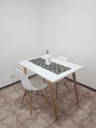 a white dining table with two chairs and a table at Departamento con COCHERA - Santa Fe in Santa Fe