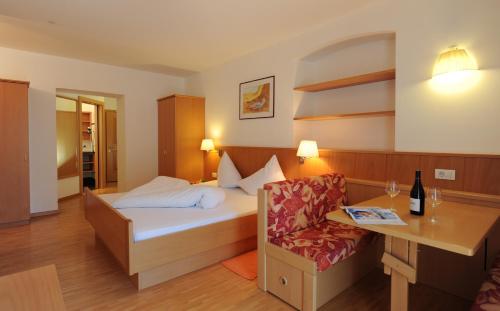 a hotel room with a bed and a chair at Gasthof Stern in Prato allo Stelvio