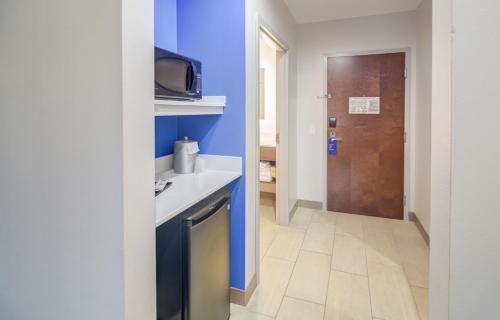 eine kleine Küche mit einem Waschbecken und einer Tür in der Unterkunft Holiday Inn Express Hotel & Suites Foley, an IHG Hotel in Foley