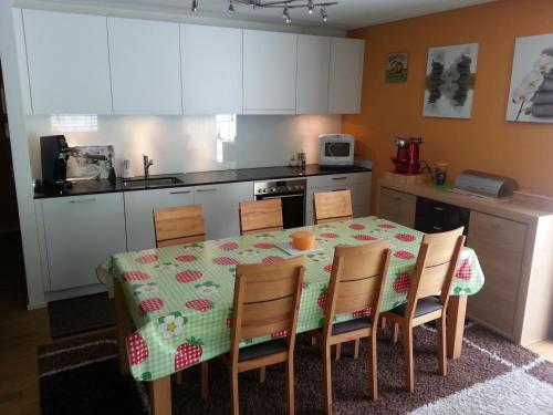 a kitchen with a table with chairs and a kitchen with white cabinets at Realp-Andermatt 3,5 locali al centro delle piste di sci di fondo con giardino privato Piste da sci Andermatt raggiungibili direttamente prendendo il treno davanti a casa in Realp