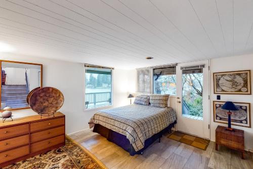 a bedroom with a bed and a dresser and windows at Delake House in Otis