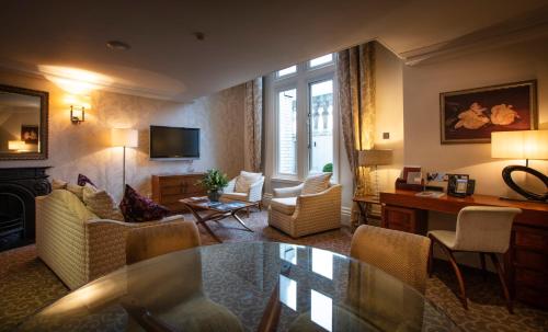 a living room with a couch and a table at The Royal Horseguards Hotel, London in London