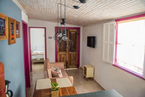 ein Wohnzimmer mit einem Sofa und einem Tisch in der Unterkunft Aconchego de Tiradentes in Tiradentes