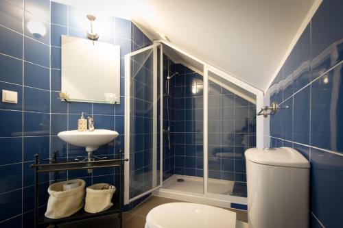 uma casa de banho em azulejos azuis com um WC e um lavatório em Tram Apartments em Sintra