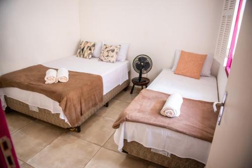 ein Schlafzimmer mit 2 Betten und Handtüchern darauf in der Unterkunft Aconchego de Tiradentes in Tiradentes