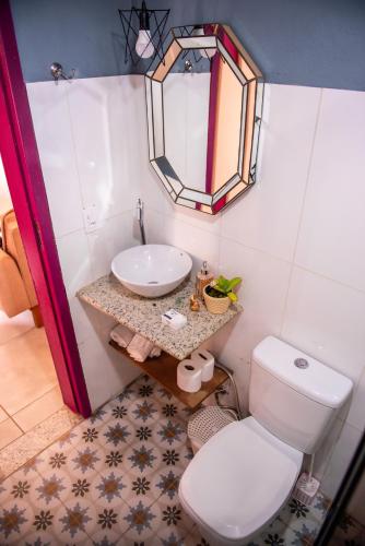 a bathroom with a white toilet and a sink at Aconchego de Tiradentes in Tiradentes
