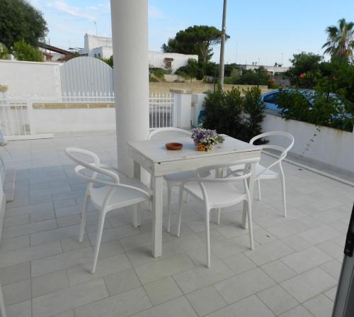 a white table and chairs on a patio at A Pochi Metri Dal Mare in Marina di Mancaversa