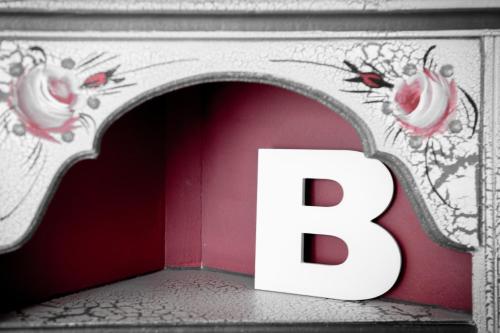a white letter b in a room with a wall at Tram Apartments in Sintra