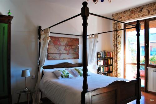 a bedroom with a canopy bed with a window at La terrazza di Anna in Sassari