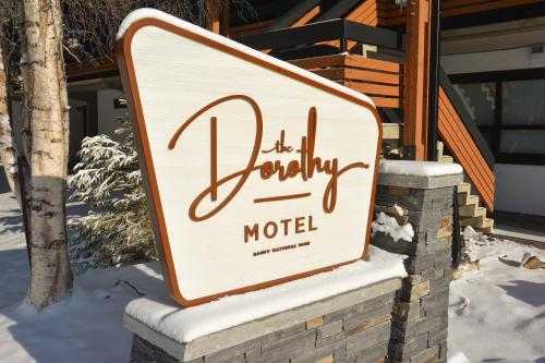 a sign for a hotel in the snow at The Dorothy Motel in Banff