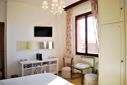 a bedroom with a bed and a table and a tv at La terrazza di Anna in Sassari
