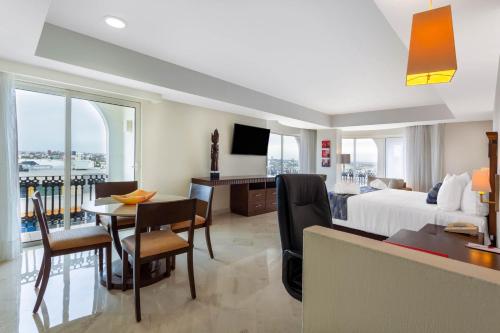 a hotel room with a bed and a desk and a table at Ramada Plaza by Wyndham Veracruz Boca del Rio in Veracruz
