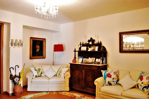 a living room with two white chairs and a chandelier at La terrazza di Anna in Sassari