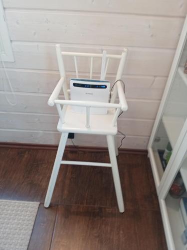 a white rocking chair with a computer on it at Tarula Holiday Home in Melkoniemi