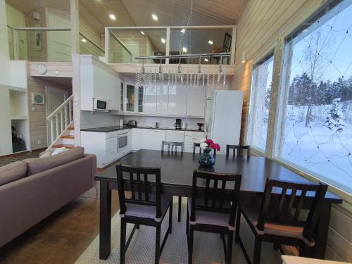 a kitchen and dining room with a table and chairs at Tarula Holiday Home in Melkoniemi