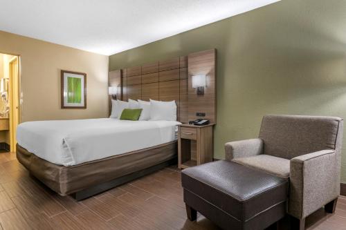 a hotel room with a bed and a chair at Best Western Downtown Stuart in Stuart