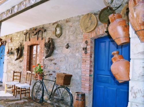 una casa con una puerta azul y una bicicleta estacionada fuera en Casa Rural El Corredor en Cabornera de Gordón en Cabornera