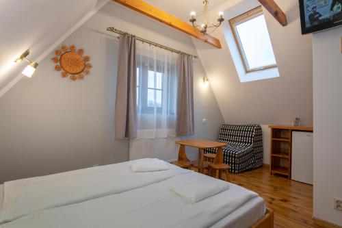 a bedroom with a bed and a table and a window at Willa pod Szrenicą in Szklarska Poręba