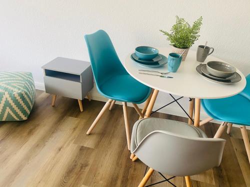 una mesa con 4 sillas y una mesa con platos y platos en See Apart 3 en Öhningen
