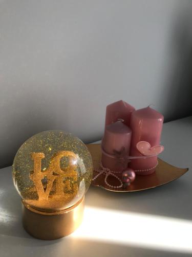 a table with a snow globe and candles on a plate at Apartament Romantyczny in Sandomierz