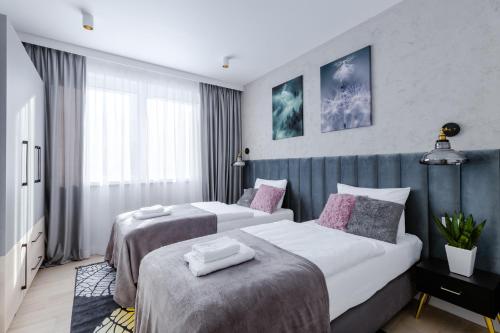 a hotel room with two beds and a window at Śnieżka Exclusive Apartamenty in Kowary